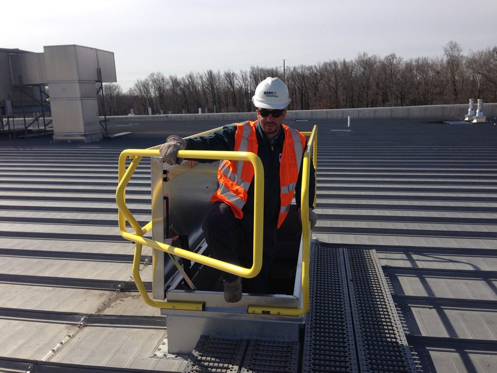 GSM worker testing SafePro Roof Safety Hatch Rail after installation.