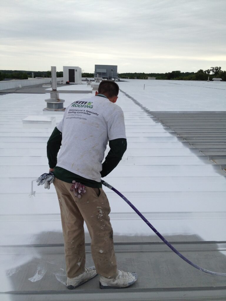Commercial roofing contractor applying white roof coatings for rooftop