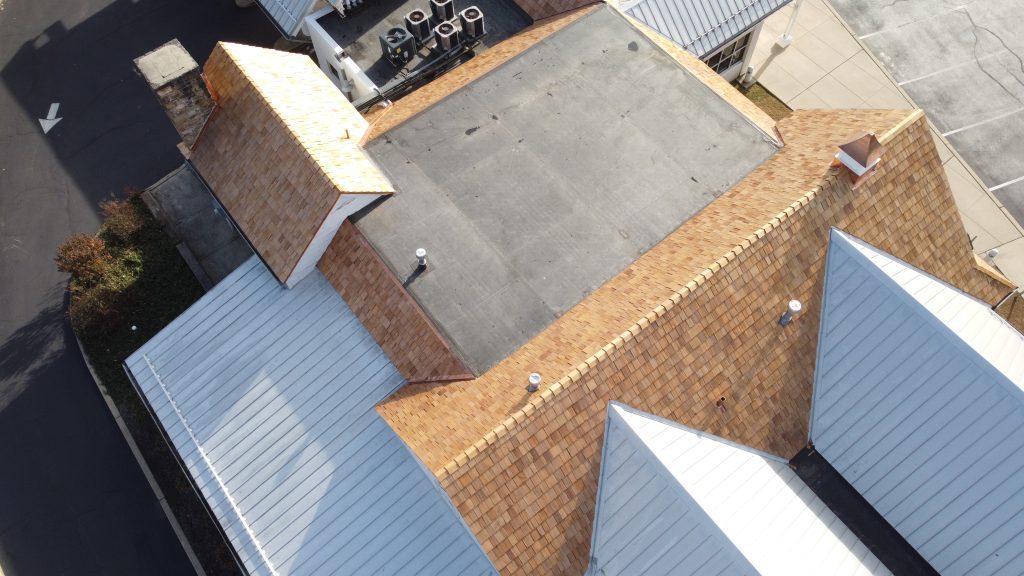 Close-up aerial view of cedar shingles with copper flashings on S&T Bank roof.