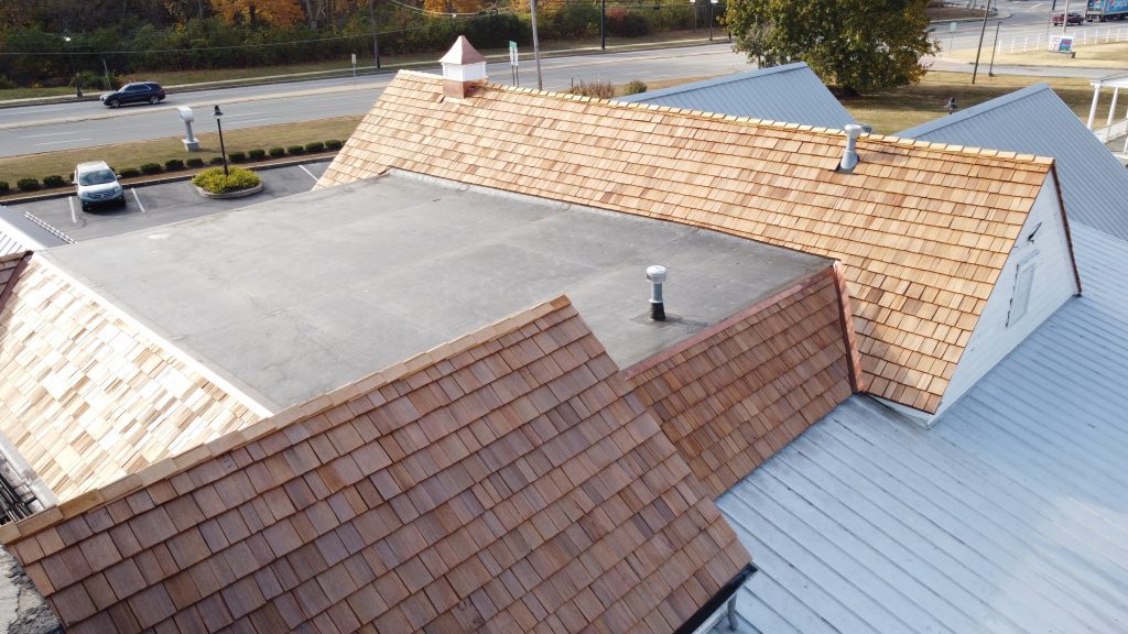 Restored cedar shake roof on S&T Bank with newly installed premium cedar shingles and copper cupola.