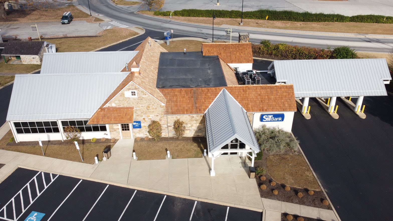 Aerial view showing the restored cedar shake roof, EPDM section, and metal roofing on S&T Bank