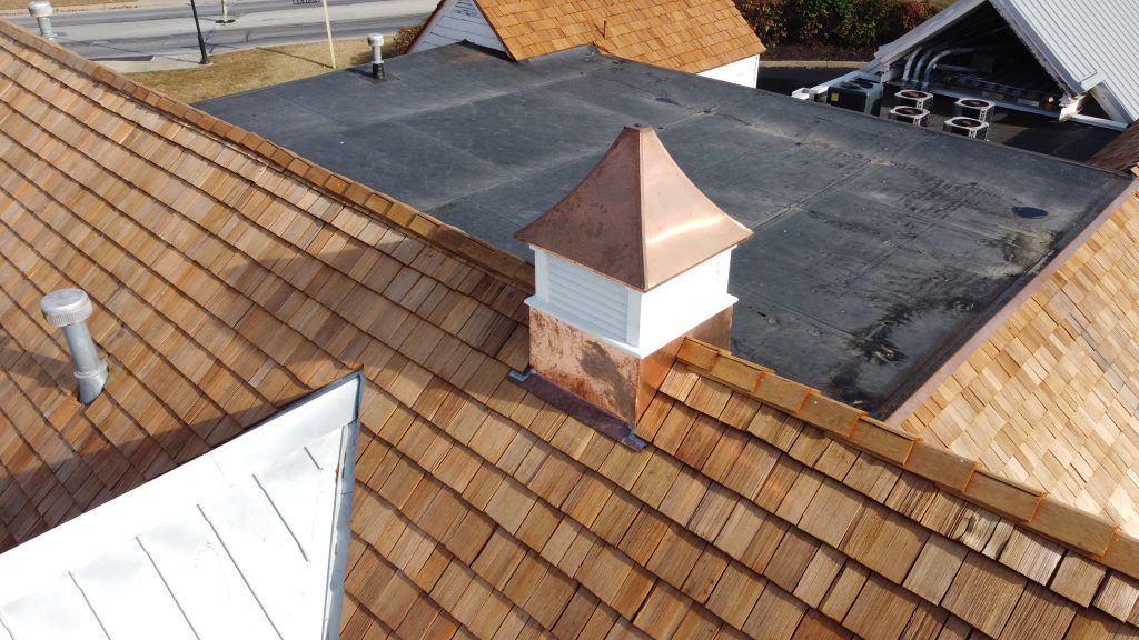 Detailed view of copper-capped cupola on newly installed cedar shake roof by GSM Roofing.