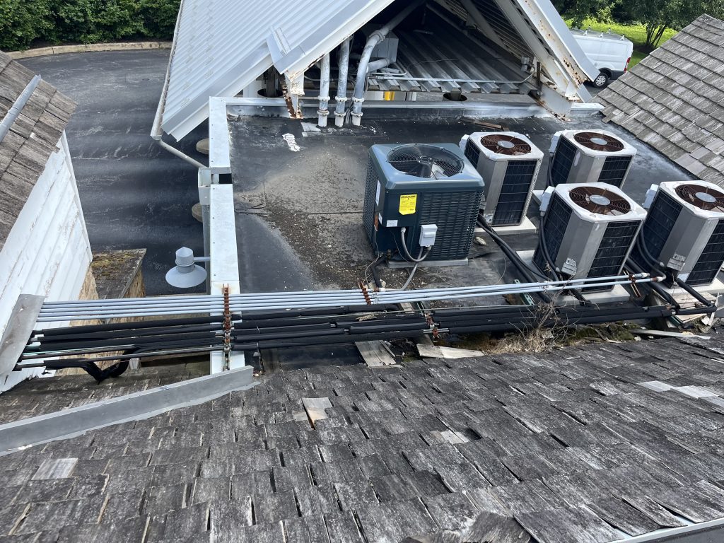 Commercial roof area with condensing units and deteriorated EPDM roofing material before GSM Roofing’s restoration.