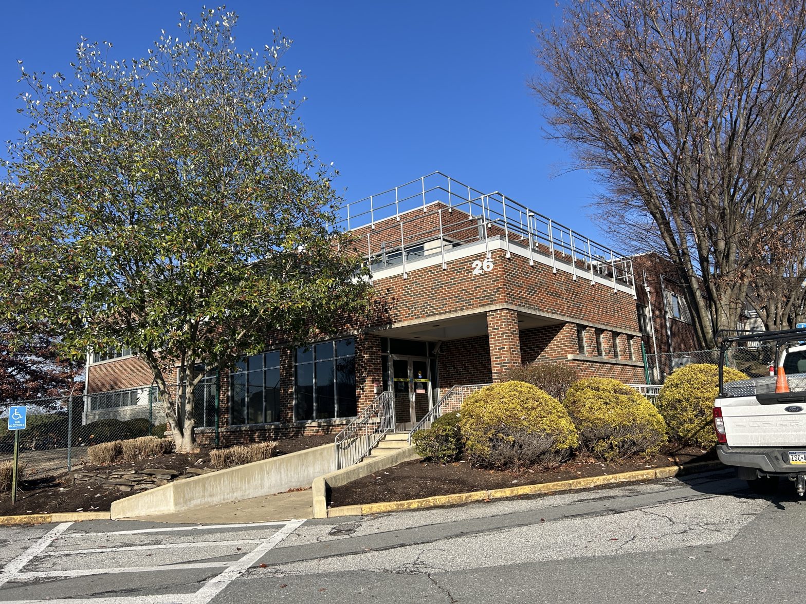 Full view of GSK Building 26 in Marietta, PA, featuring the completed perimeter safety rail system installed by GSM Roofing for enhanced rooftop safety.