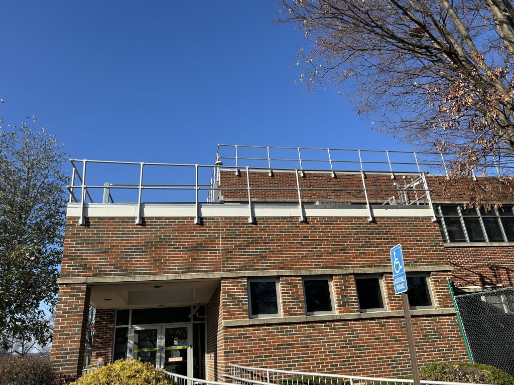 Wall-mounted safety rails installed on the low roof area of GSK Building 26, providing enhanced fall protection.