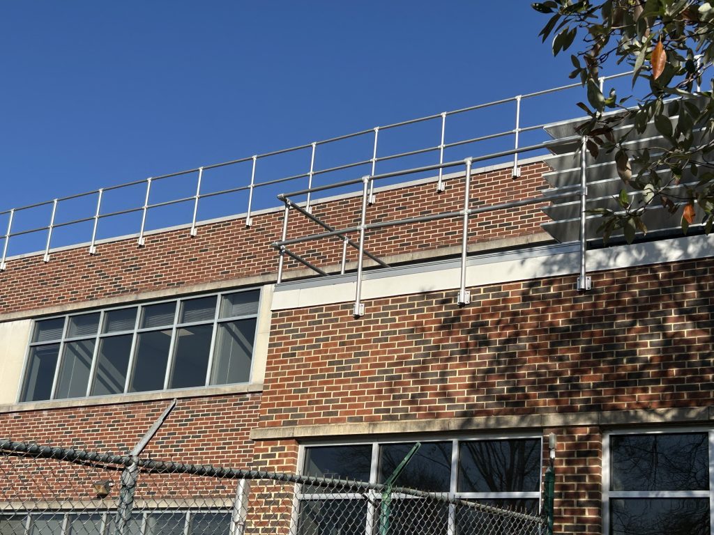 High-reach installation of a custom safety rail system matching the existing setup at GSK Building 26 in Pennsylvania