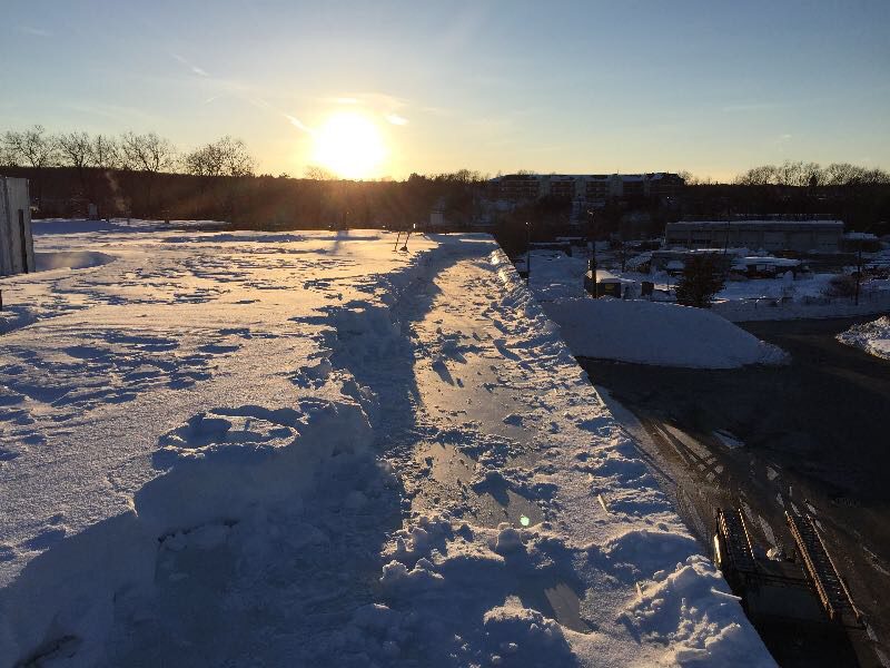 Commercial roof snow removal by GSM Roofing—essential winter maintenance to prevent costly damage.