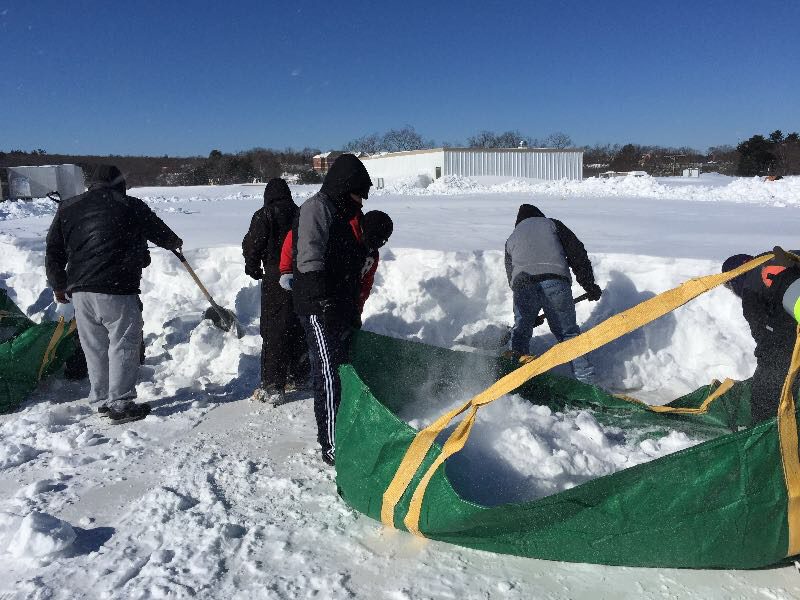 Commercial rooftop snow removal in progress by GSM Roofing to reduce ice buildup and prevent leaks.