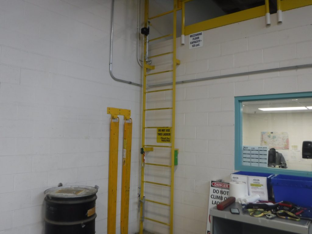 Fixed dock ladder inside TE Connectivity facility in Middletown, PA, before fall protection system installation.