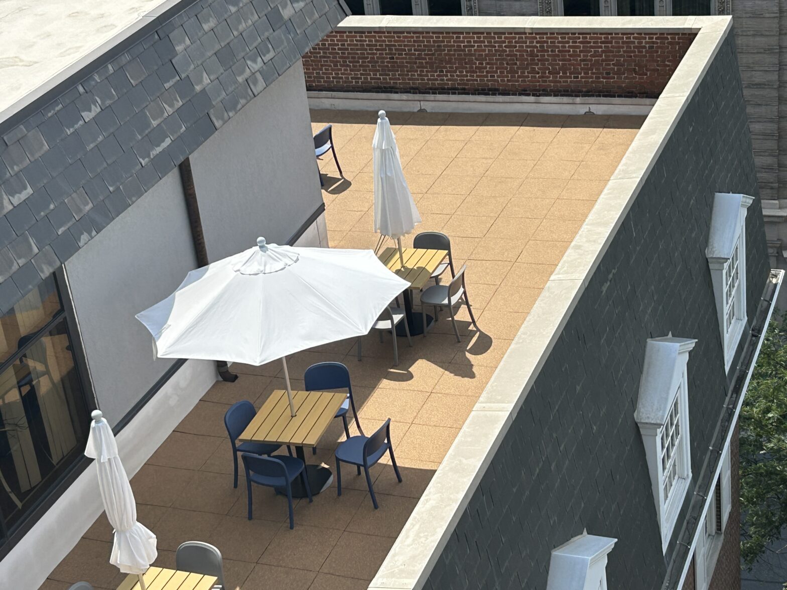 Overhead perspective of GSM Roofing's completed rooftop patio project with rubber tiles and employee seating space.