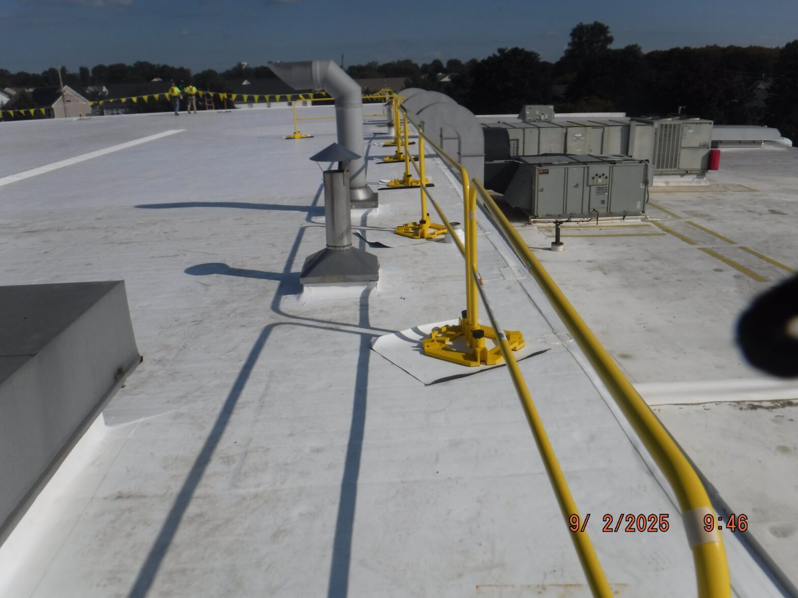 GSM Roofing’s completed TPO system with visible safety railings and mechanical equipment set on protective pads.